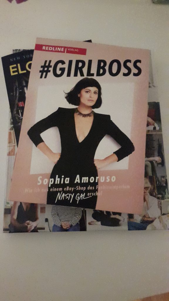 A picture of Sophia Amoruso's book #GIRLBOSS stacked on top of two other books.