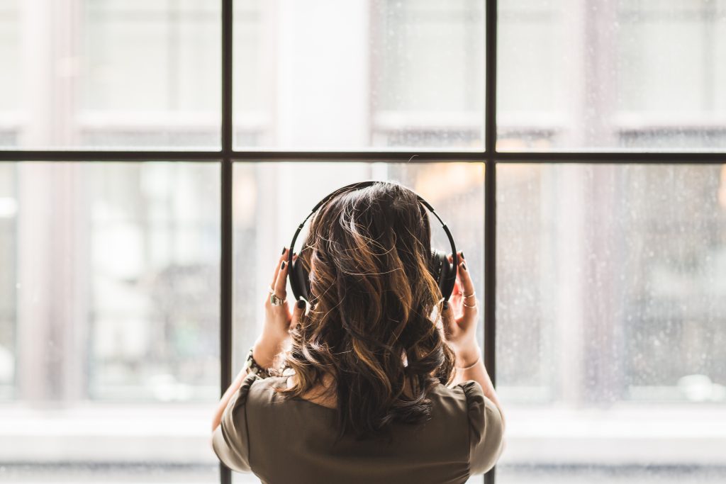 women with earphones listening to music - winter blues